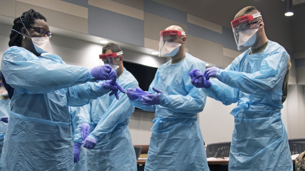 Members of the Florida National Guard (FLNG) gather with local hospital staff to collaborate on donning and doffing personal protective equipment (PPE) during Task Force – Medicals’ response to the COVID-19 virus, March 17, 2020